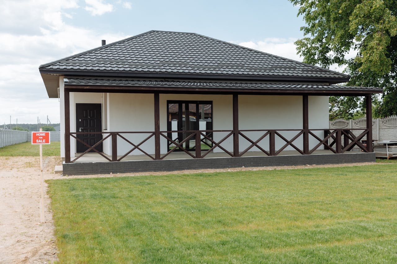 Modern house for sale with a spacious lawn and inviting facade, perfect for families.